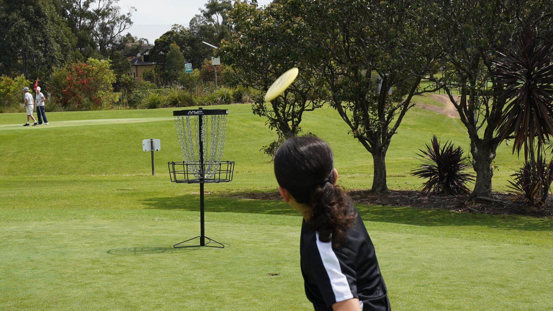 Girl playing disc golf