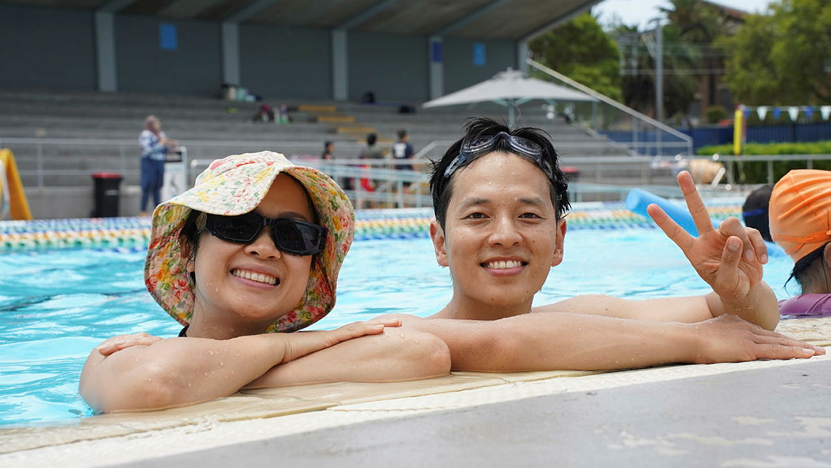 Two swimmers on side of pool